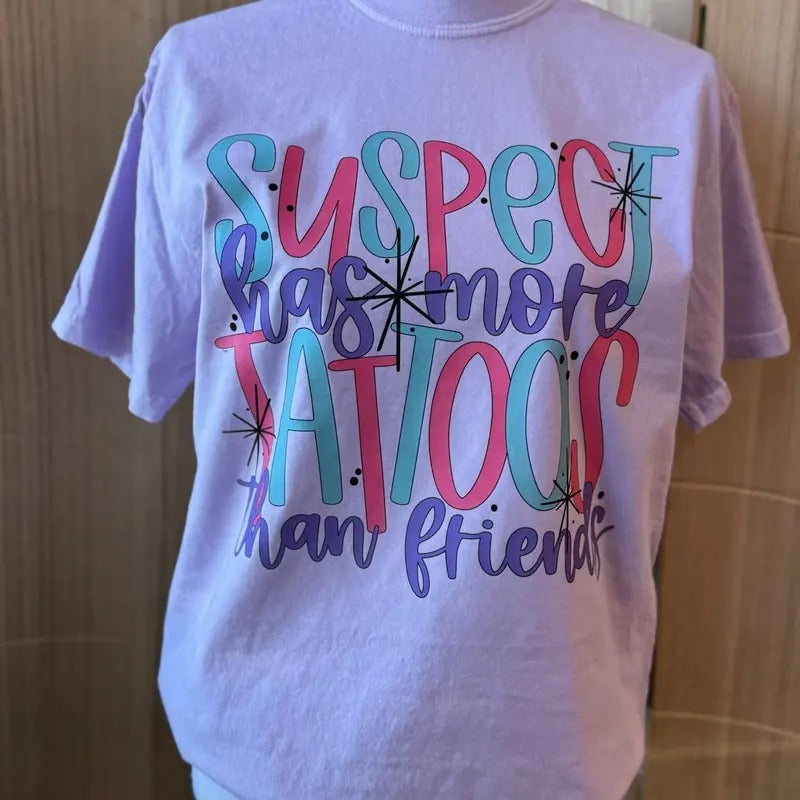 Suspect Has More Tattoos Than Friends Graphic Tee - Comfort Colors Tee - Tattoo Shirt Hoodie, Sweatshirt | RetroVerseTees.com